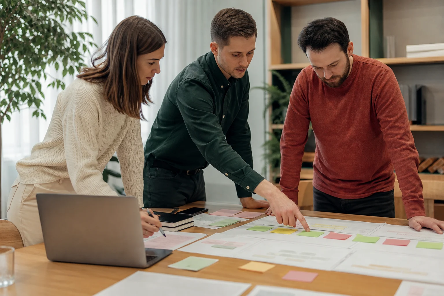 CRM-интегратор и сотрудники компании обсуждают схему этапов работы с клиентом за столом.
